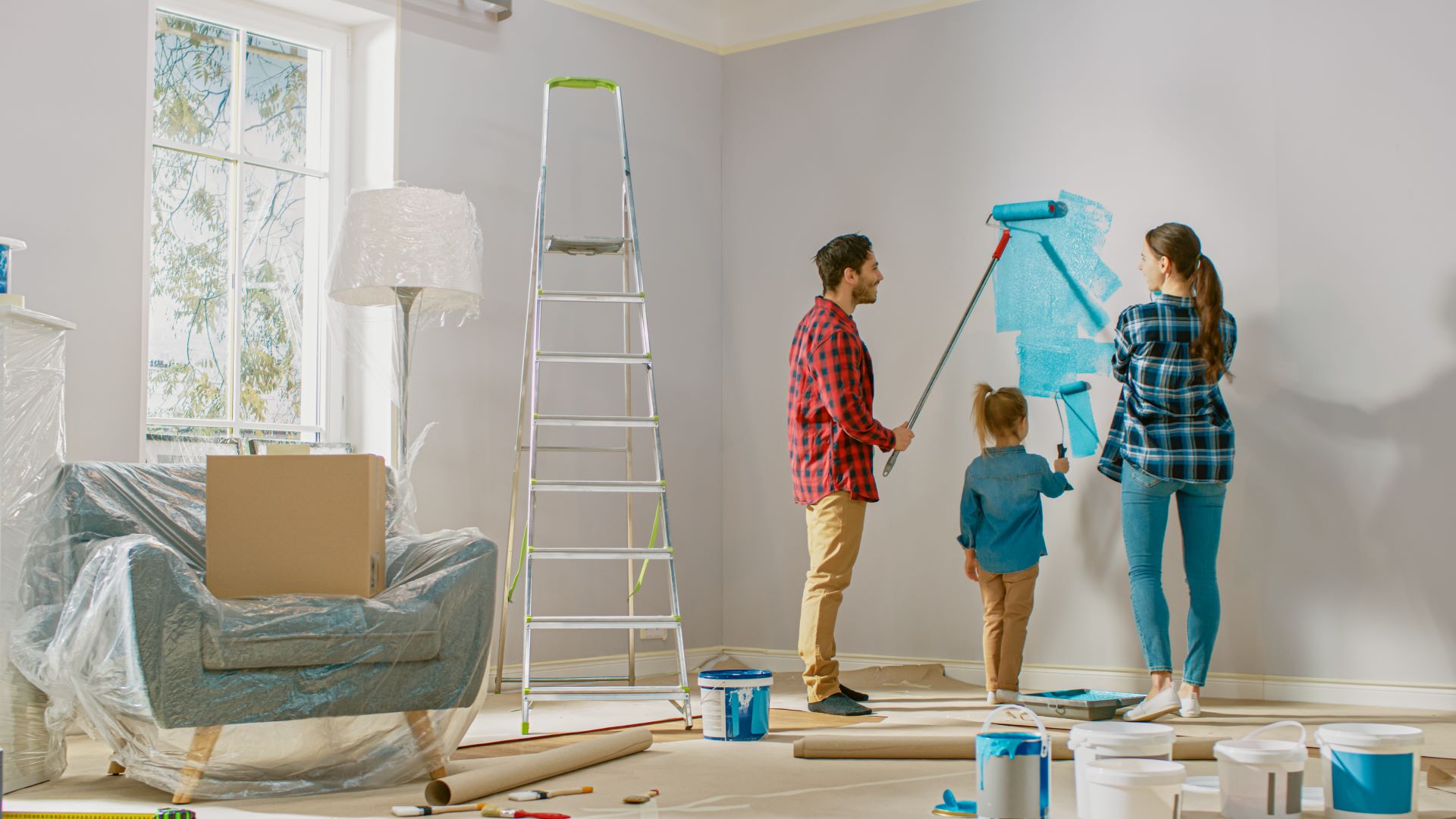 Eine Familie streicht gemeinsam die Wände in ihrem Haus