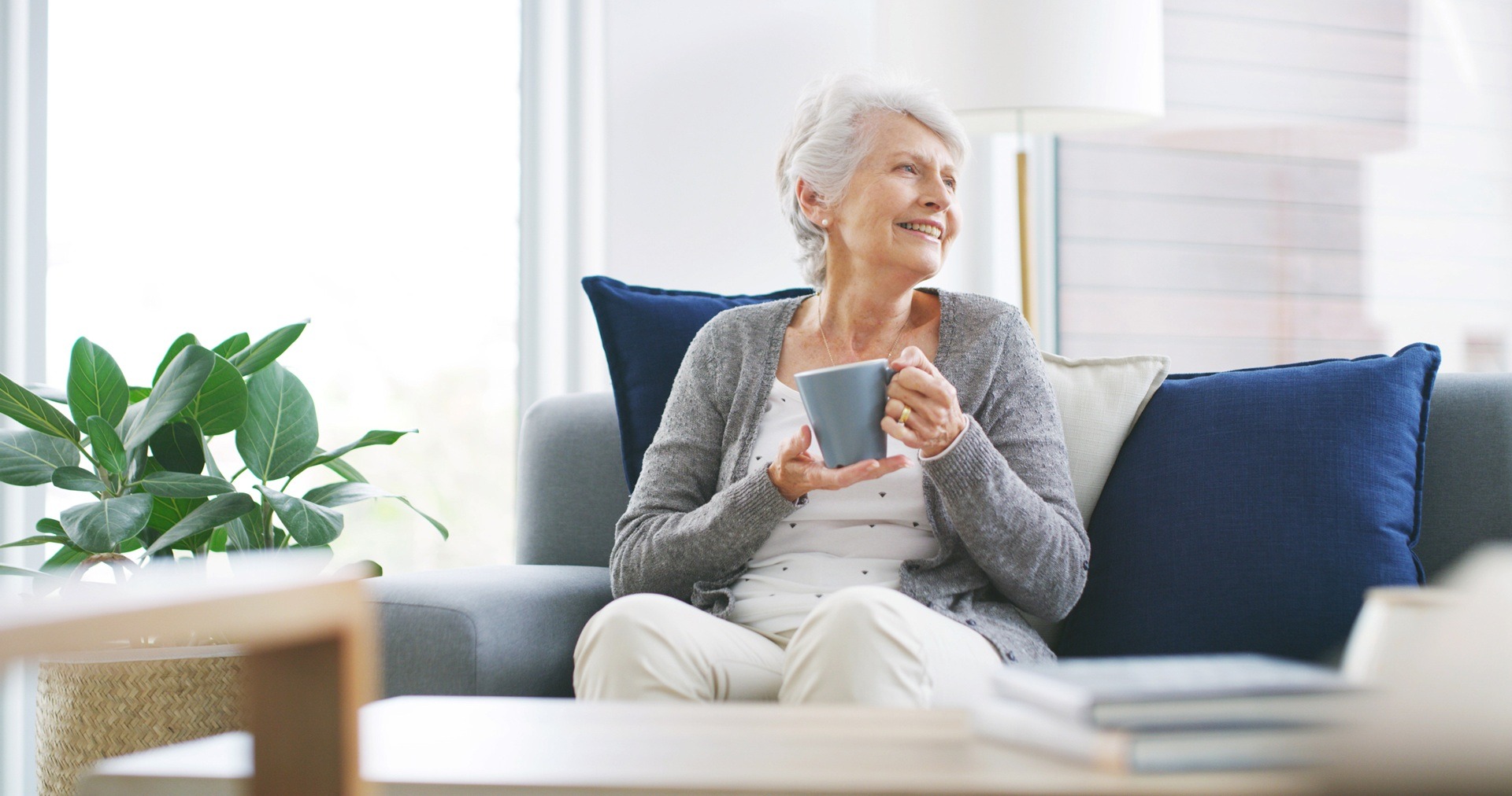 Seniorin genießt Tee im warmen Wohnzimmer | Heizölpreise München

